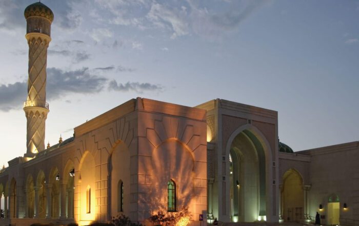 Image of an illuminated mosque with intricate architecture and serene surroundings,bytravel